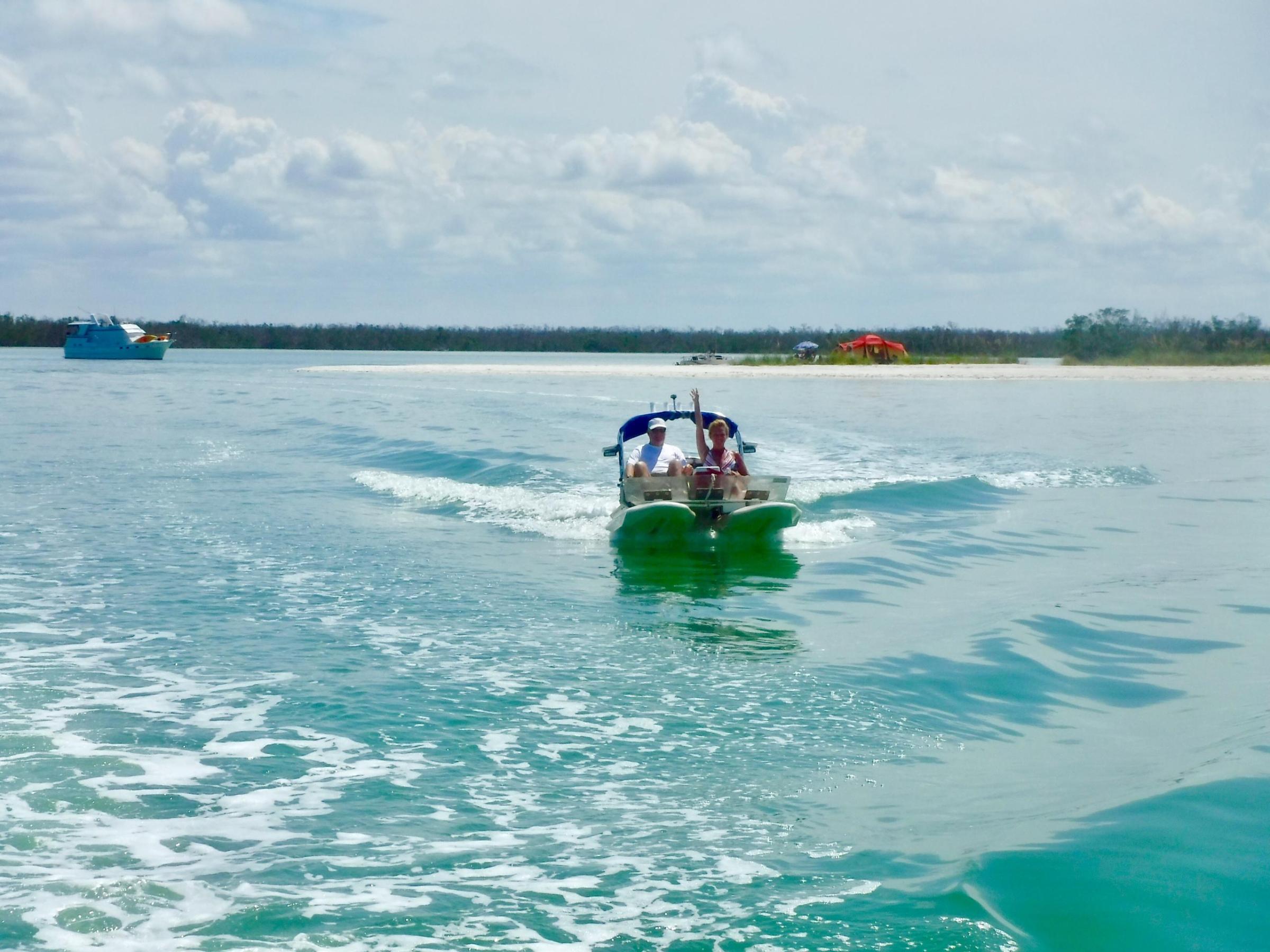 a man riding on the back of a boat in a body of water